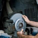 Car Mechanic holding a brake rotor during brake repair