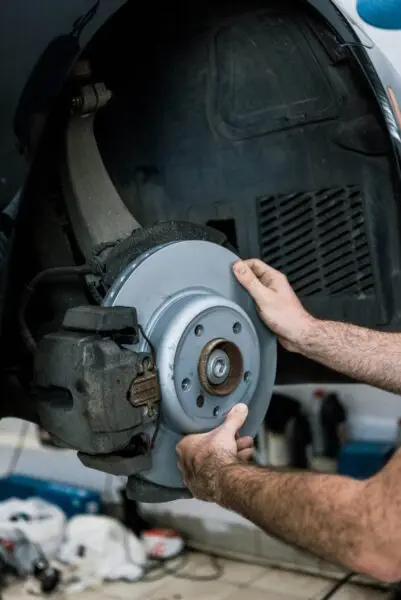 Car Mechanic holding a brake rotor during brake repair